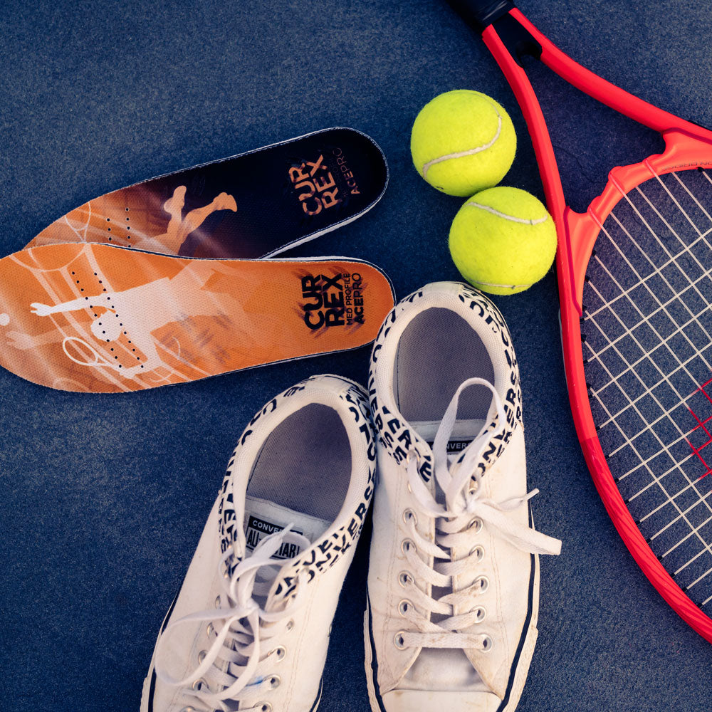 CURREX ACEPRO insoles next to white tennis shoes, yellow tennis balls, and racquet #1-wahle-dein-profil_low